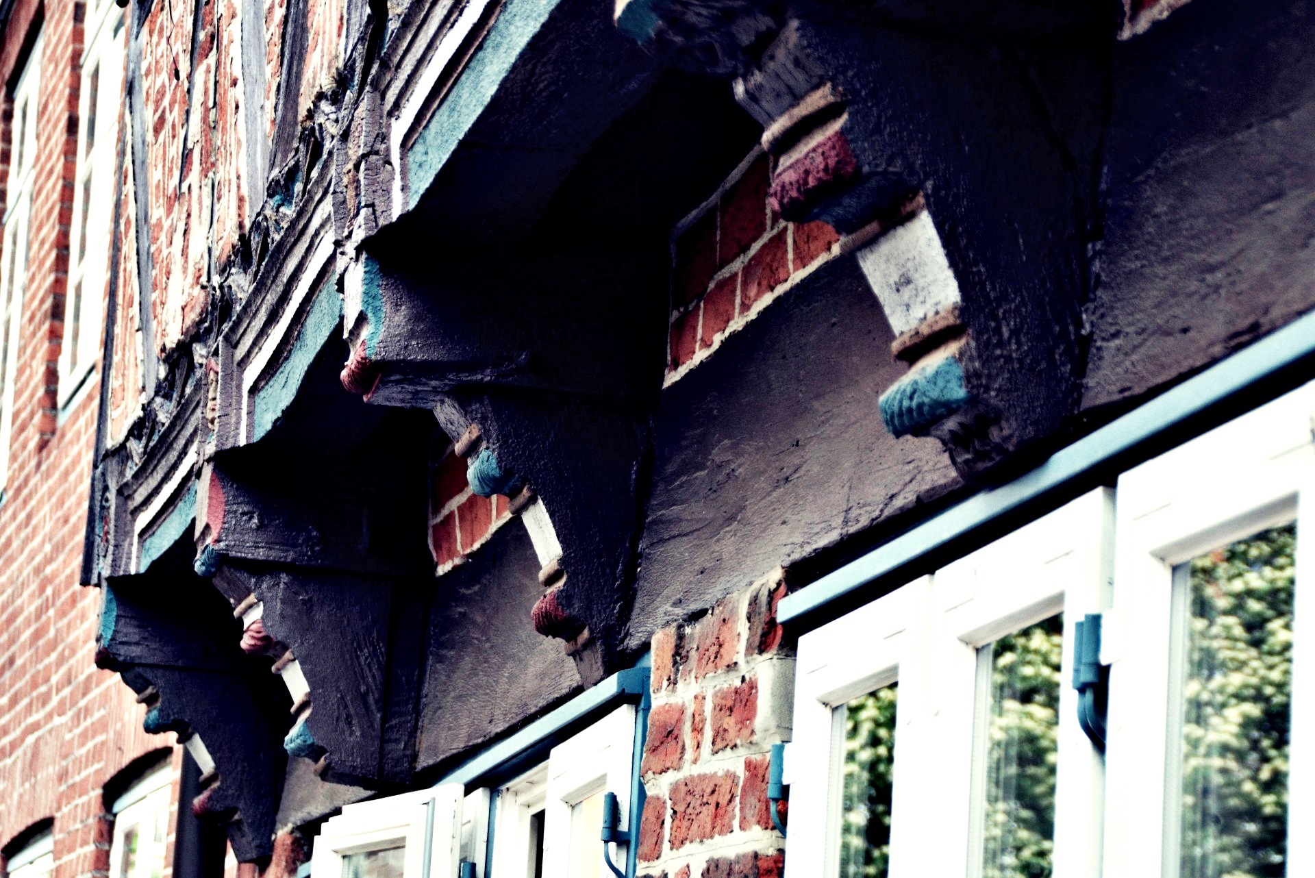 Fachwerkfassade mit geschnitzten, farbig gefassten Knaggen unter dem Stockwerks&uuml;berstand